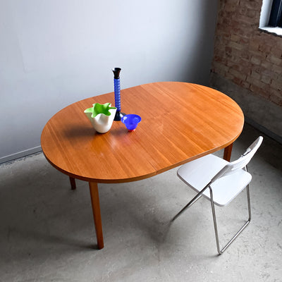 Runt matbord i teak med en iläggsskiva