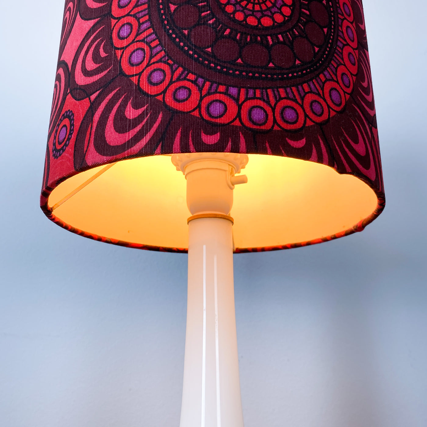 Lampa med vit glasfot och mönstrad skärm