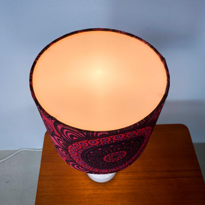 Lampa med vit glasfot och mönstrad skärm