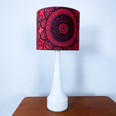 Lampa med vit glasfot och mönstrad skärm