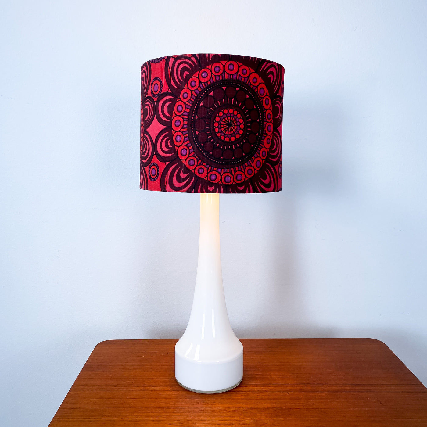 Lampa med vit glasfot och mönstrad skärm