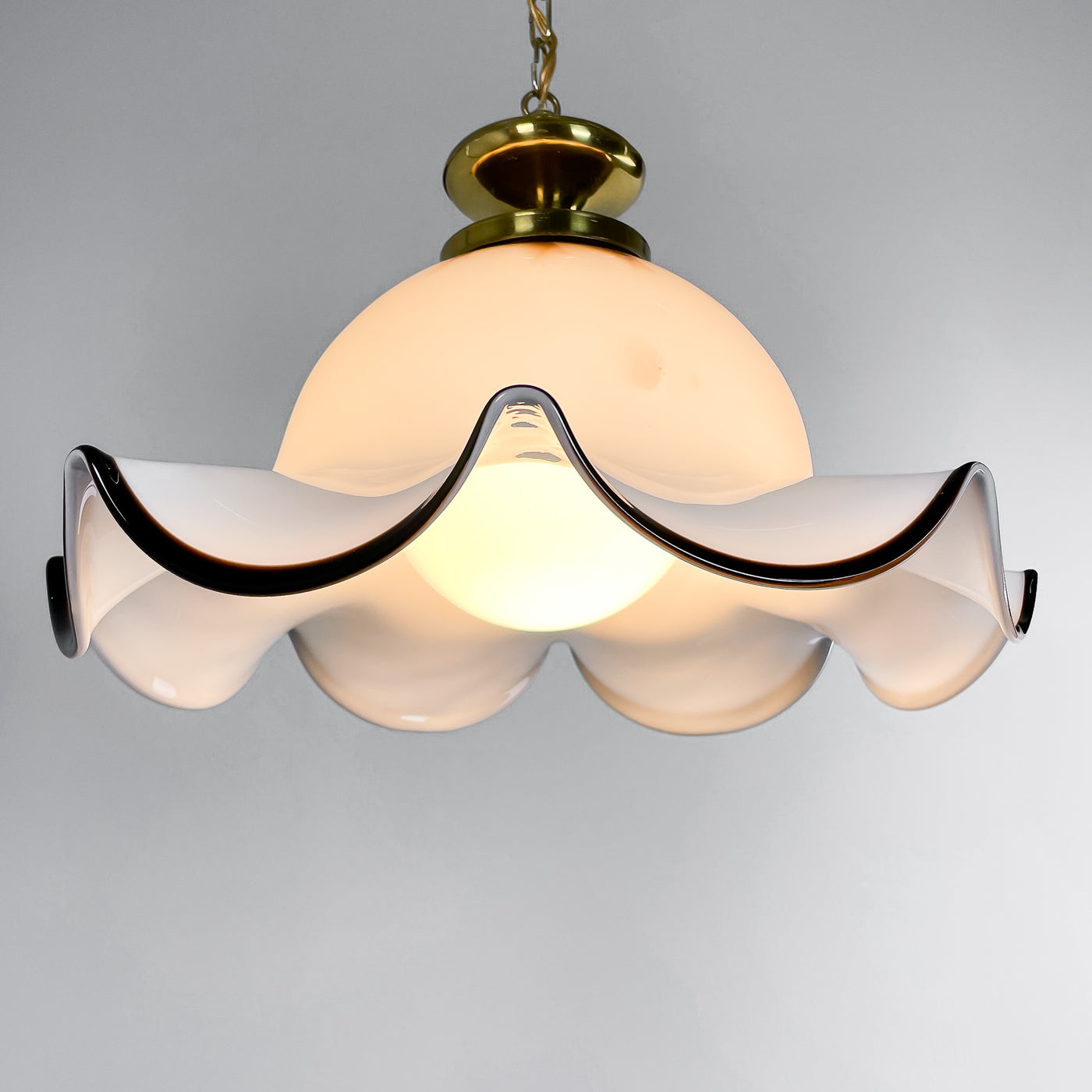 Lampa i böljande glas och mässing